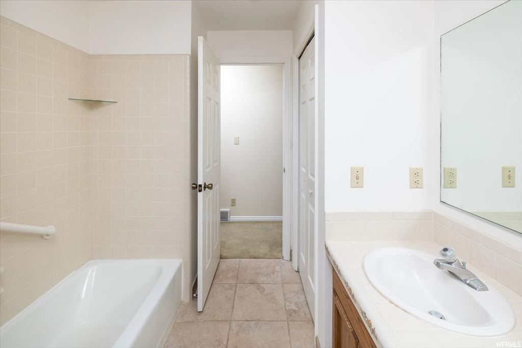 Bathroom featuring tile floors, vanity, and bathtub / shower combination