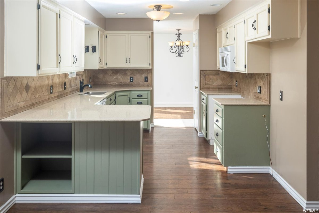 Kitchen featuring backsplash, dark hardwood / wood-style floors, and white cabinets