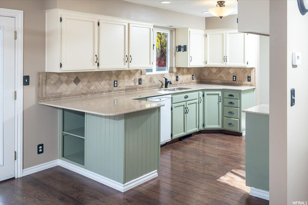 Kitchen featuring backsplash, green cabinets, white cabinetry, and dark hardwood / wood-style floors