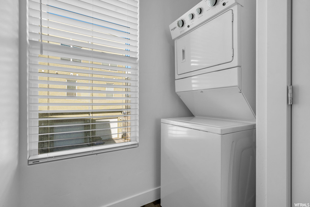 Laundry area featuring stacked washer and dryer and a wealth of natural light
