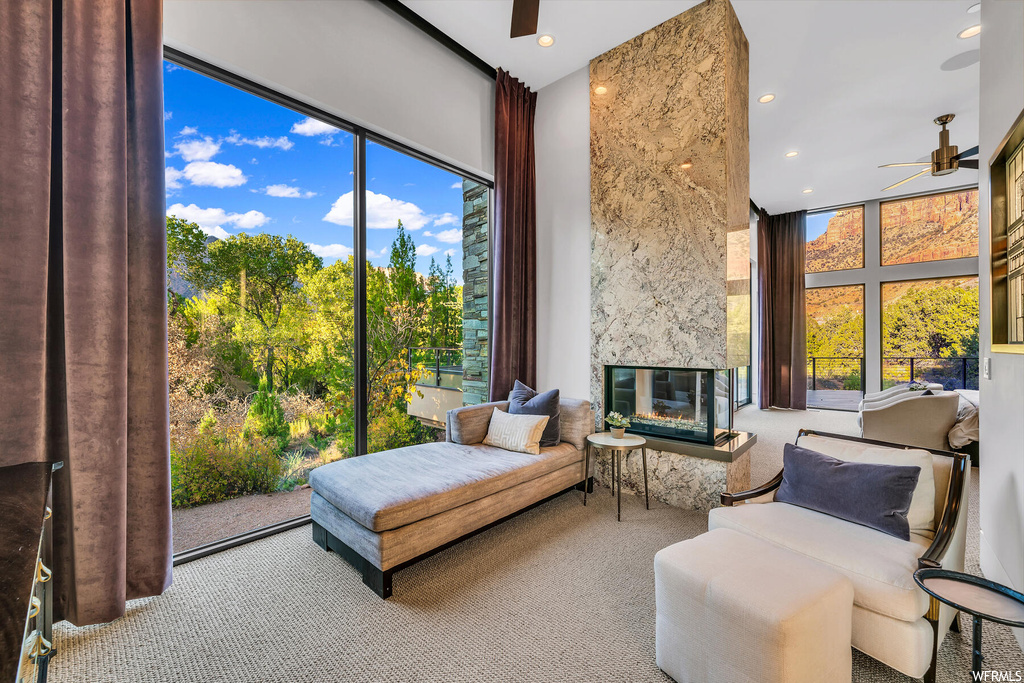 Interior space featuring a wealth of natural light, ceiling fan, a high end fireplace, and expansive windows