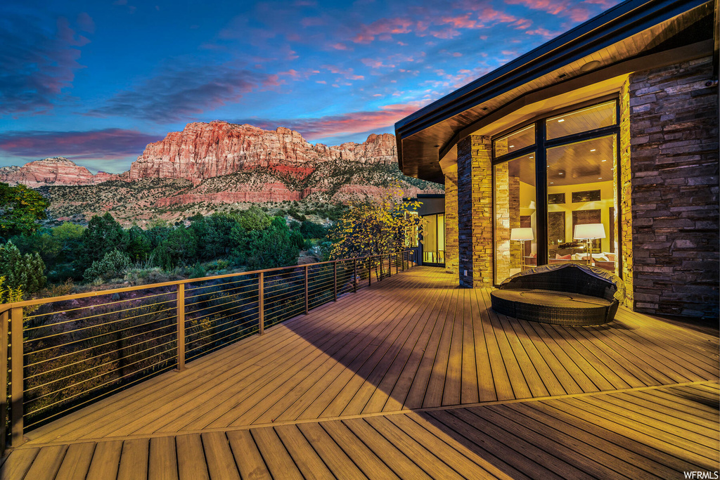 Deck at dusk featuring a mountain view