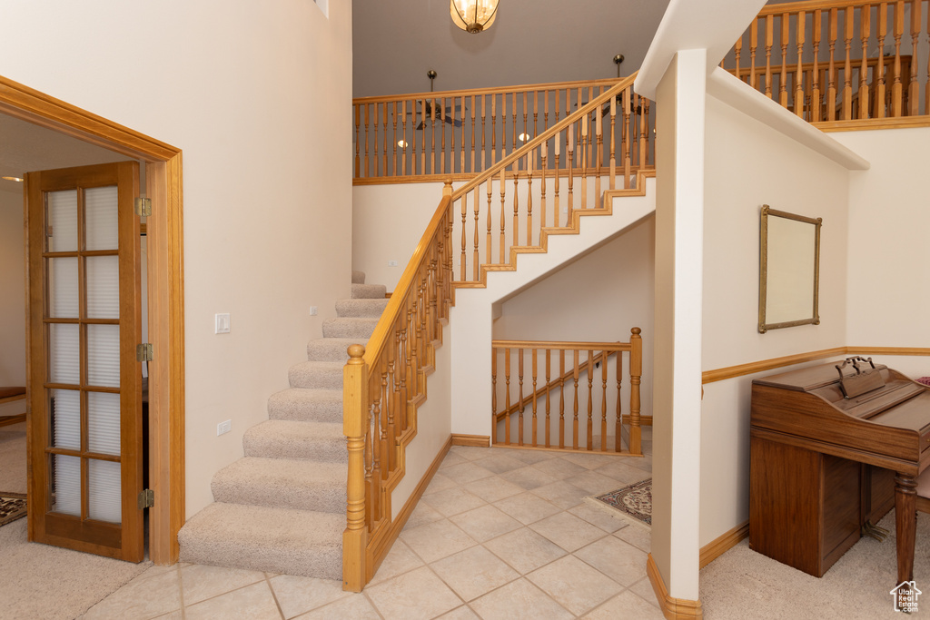 Stairs featuring tile floors and a high ceiling