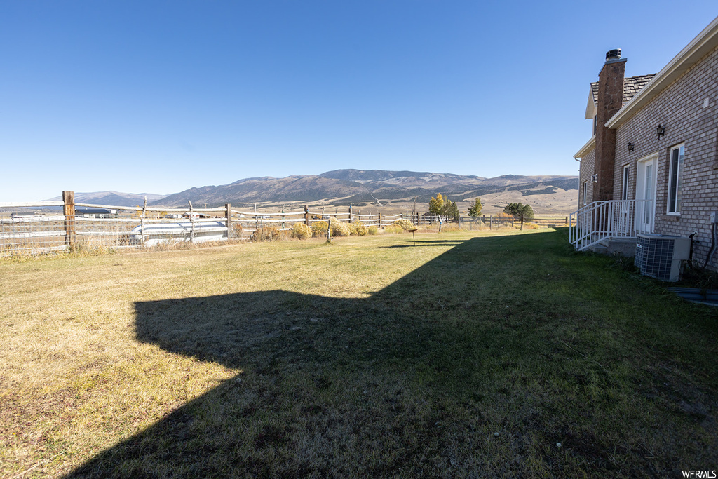View of yard featuring a mountain view, central AC, and a rural view