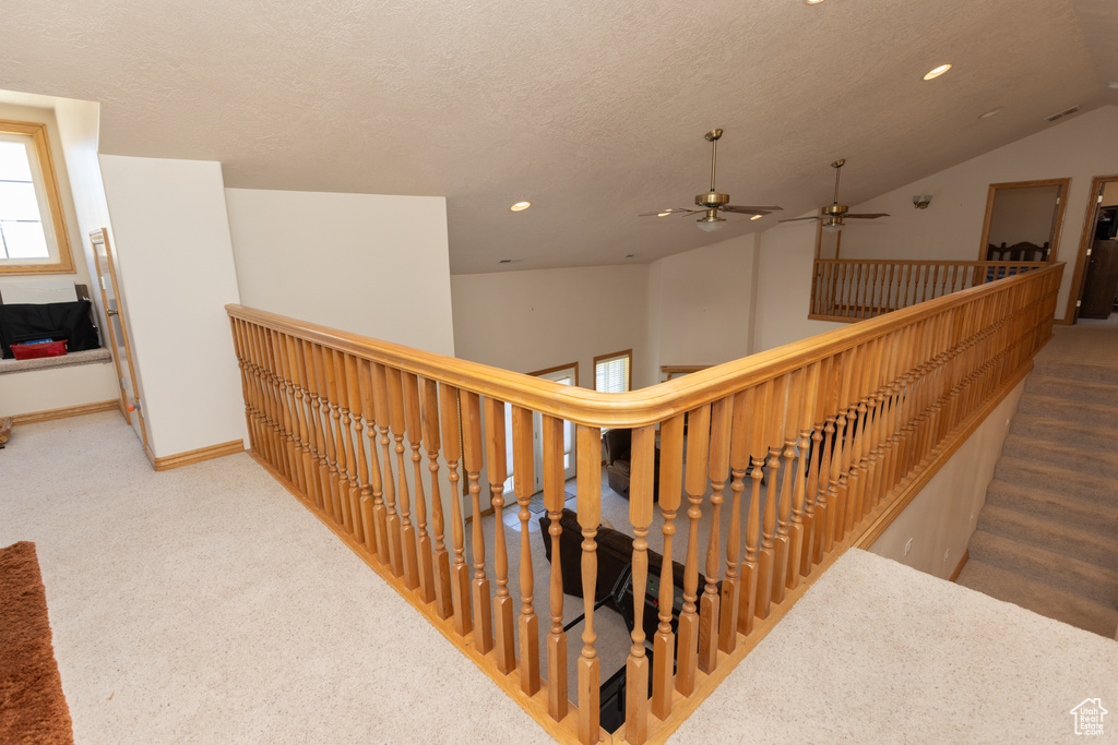 Stairway with carpet floors and vaulted ceiling