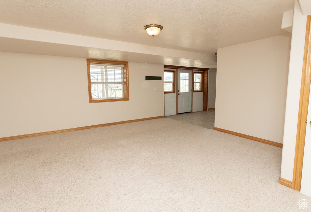 Unfurnished room featuring carpet and a textured ceiling