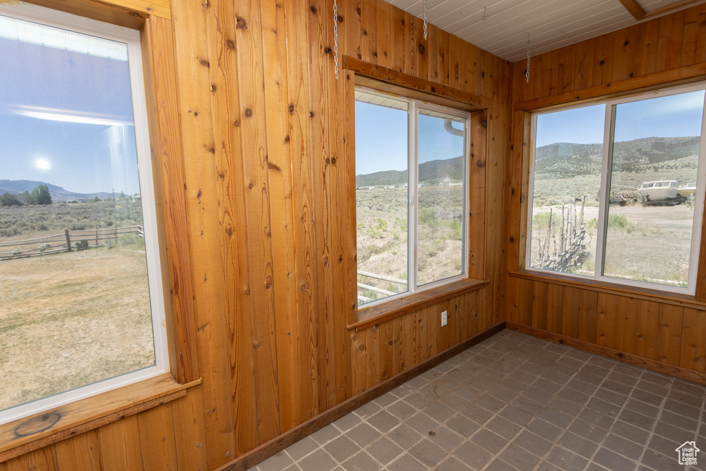 Unfurnished sunroom with a healthy amount of sunlight and a mountain view