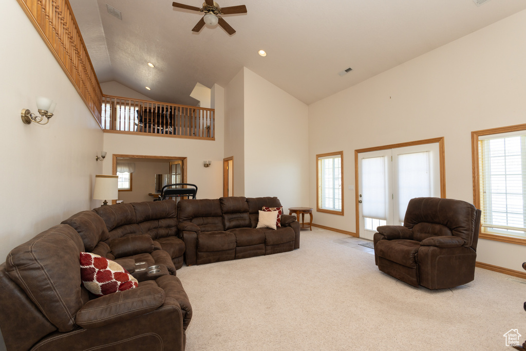 Carpeted living room featuring high vaulted ceiling, ceiling fan, and french doors