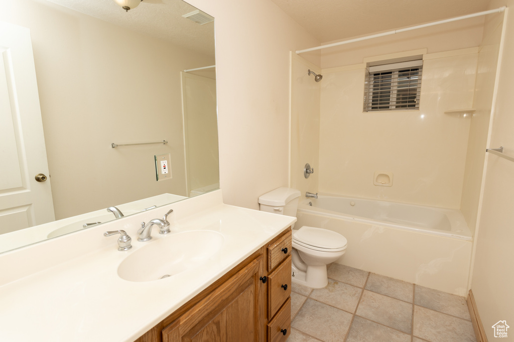 Full bathroom with tile floors, washtub / shower combination, toilet, and vanity