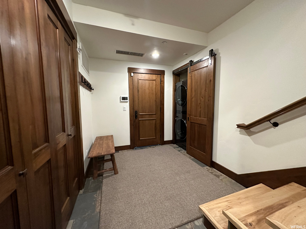 Hall featuring a barn door and carpet flooring