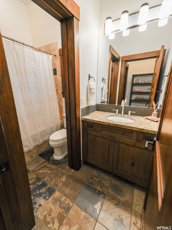 Bathroom with toilet, vanity, and tile floors