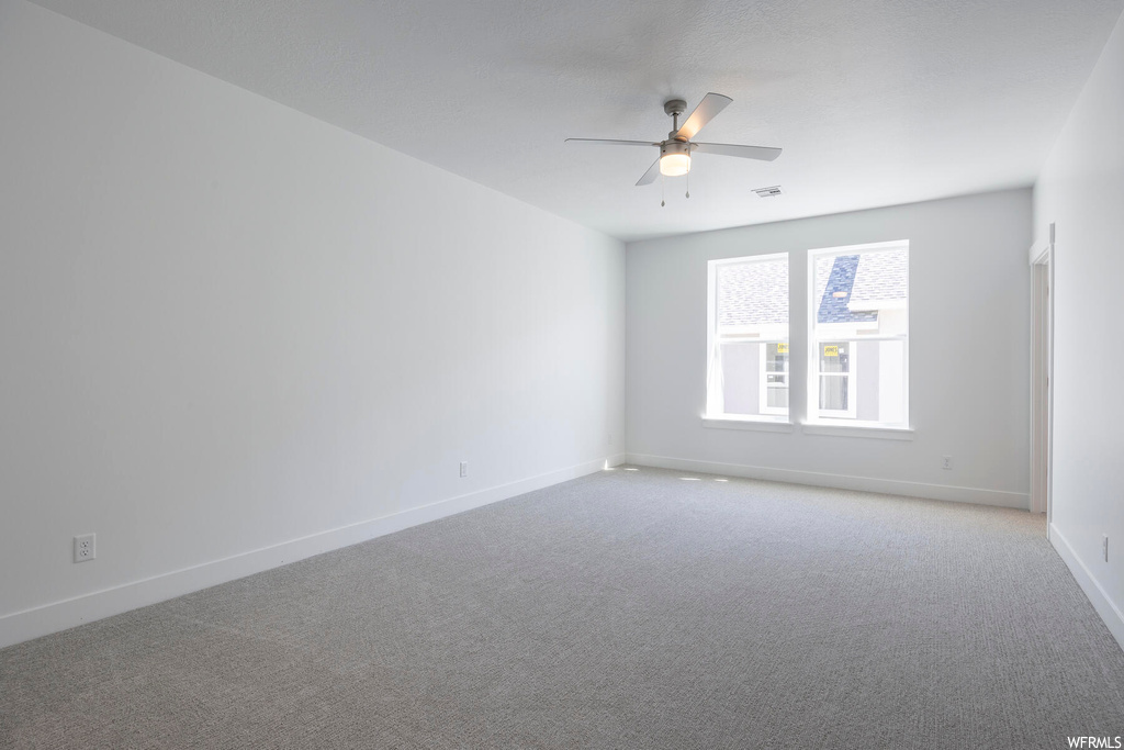 Unfurnished room featuring ceiling fan and light colored carpet