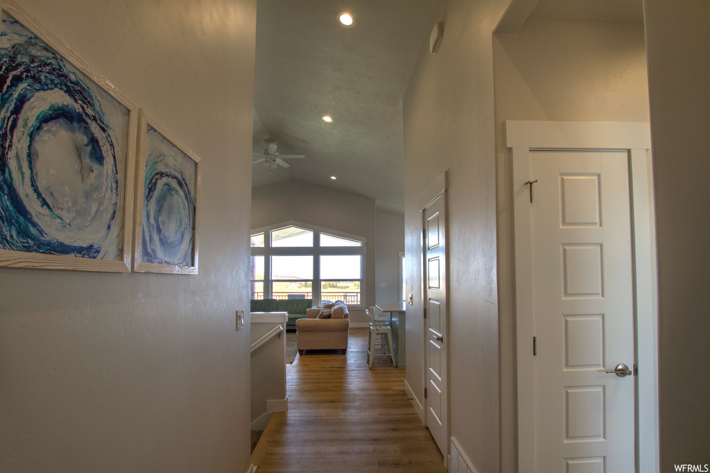 Hallway featuring hardwood / wood-style floors and vaulted ceiling