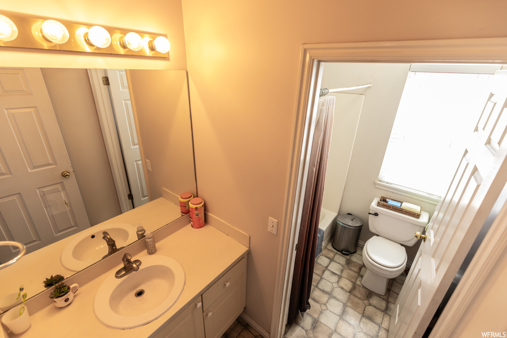 Bathroom featuring oversized vanity, toilet, and tile floors