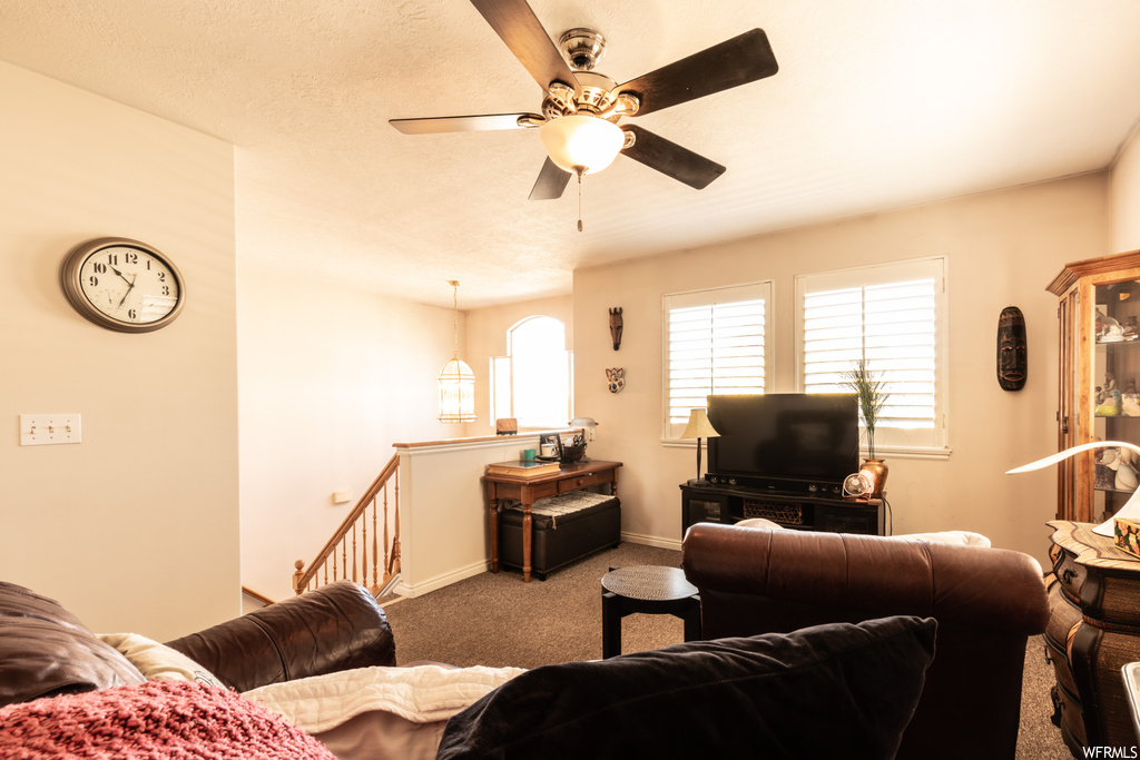 Living room featuring ceiling fan and carpet flooring