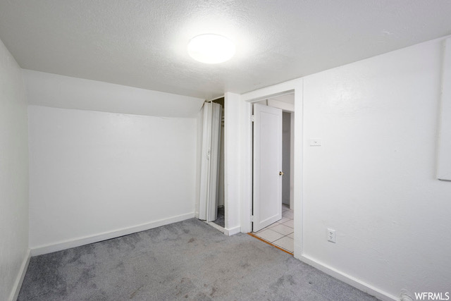 Interior space with light carpet and a textured ceiling