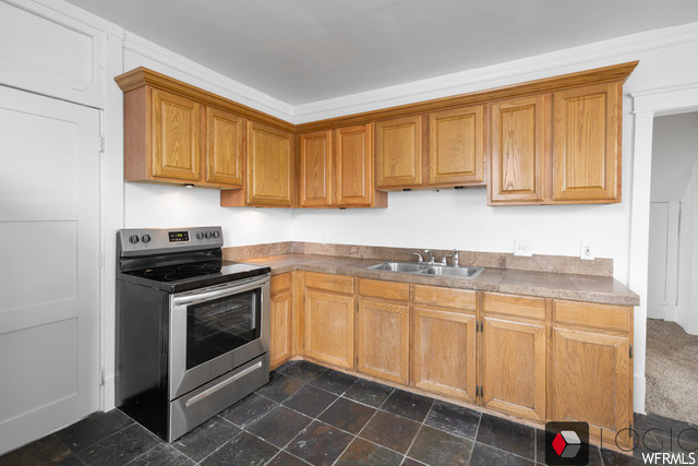 Kitchen with sink, dark tile floors, and stainless steel electric range oven