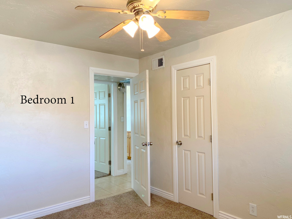 Unfurnished bedroom with ceiling fan, a closet, and light colored carpet