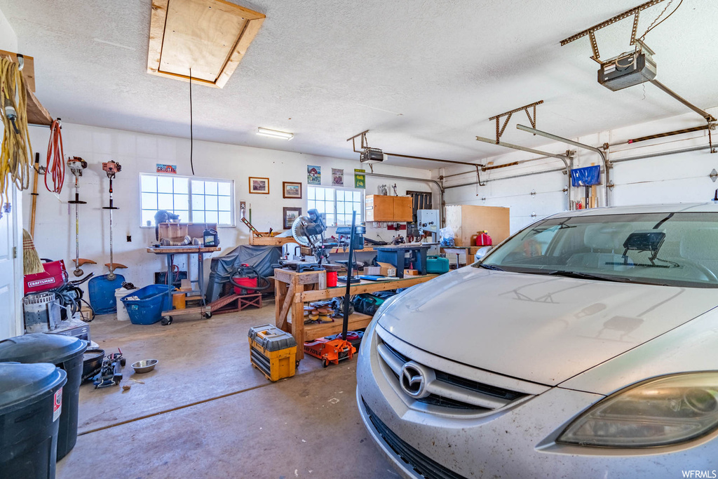 Garage with a garage door opener and a workshop area