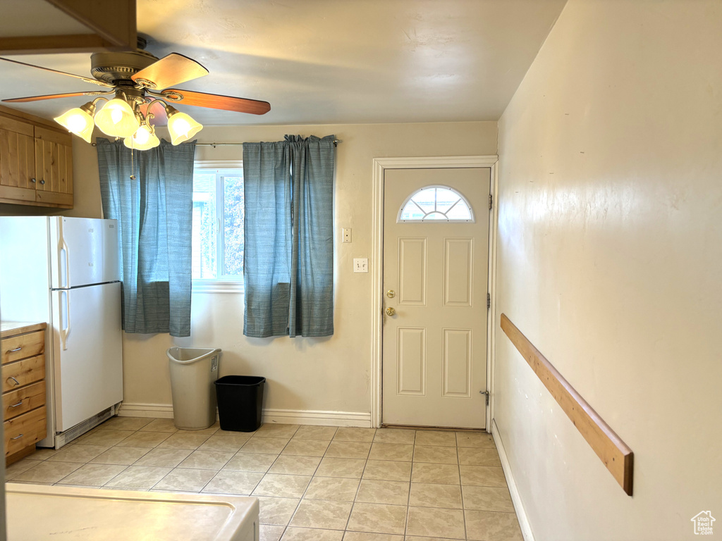 Tiled entryway featuring ceiling fan and plenty of natural light