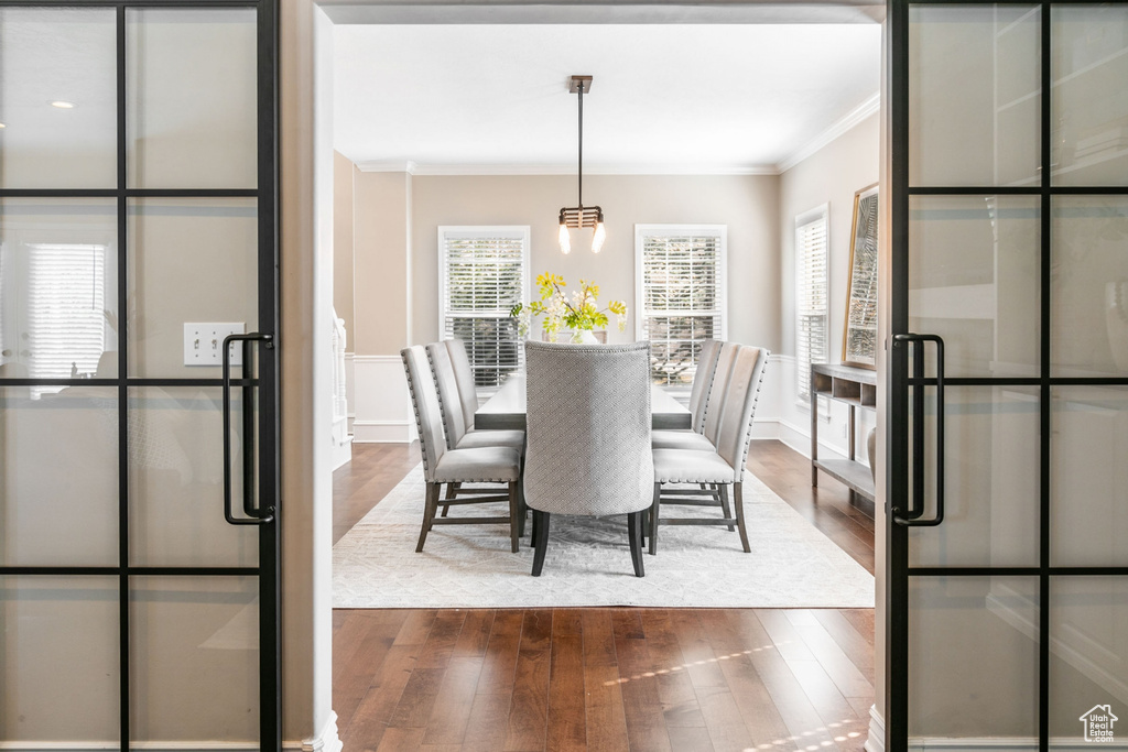 Dining area with a notable chandelier, crown molding, and hardwood / wood-style floors