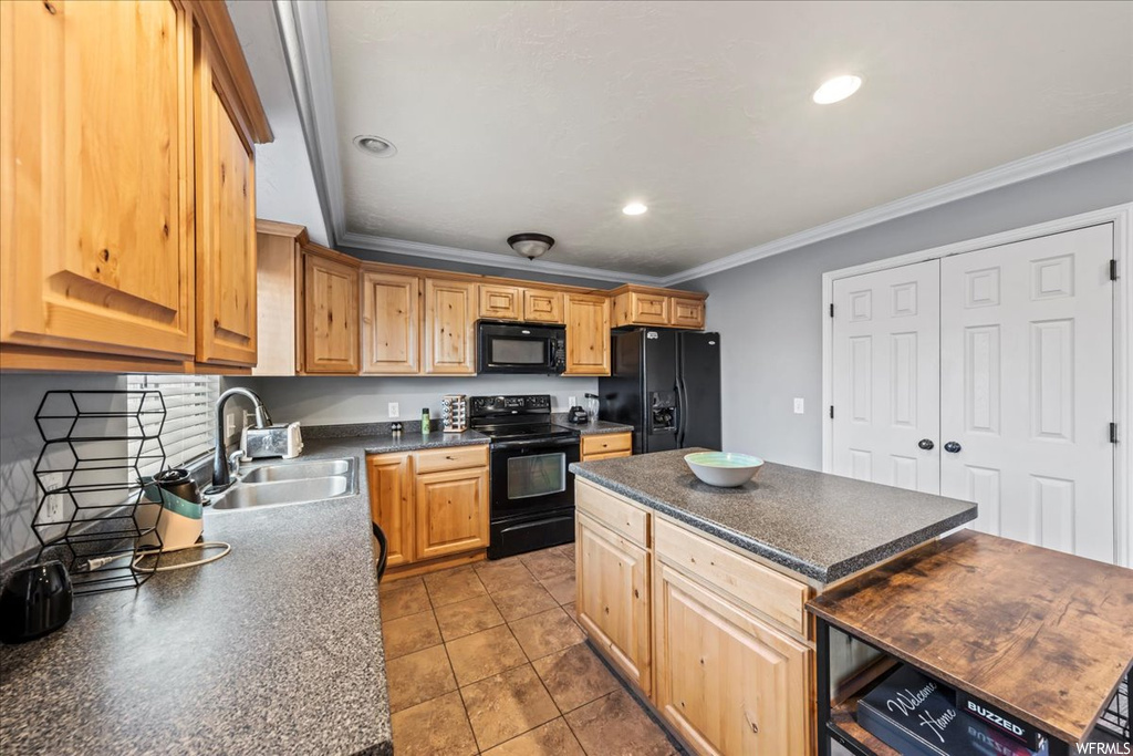 Kitchen featuring sink, a center island, ornamental molding, light tile flooring, and black appliances