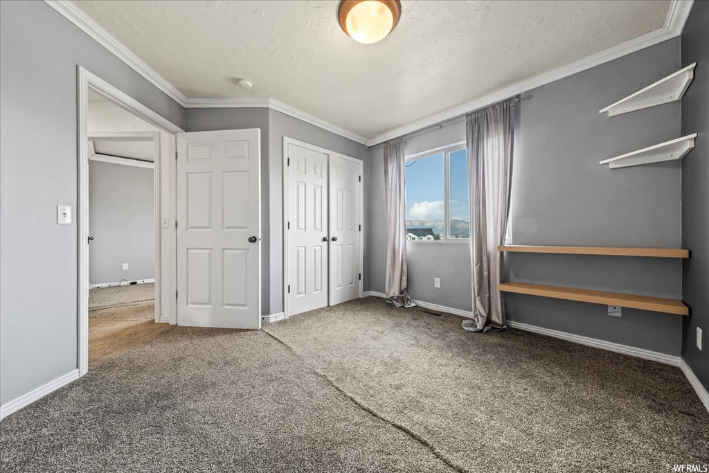 Unfurnished bedroom featuring crown molding and light colored carpet
