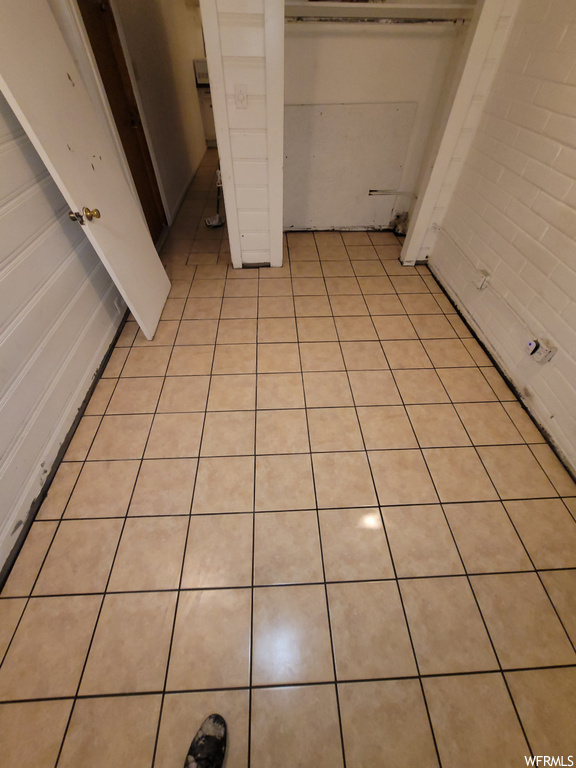 Unfurnished bedroom featuring light tile flooring and a closet