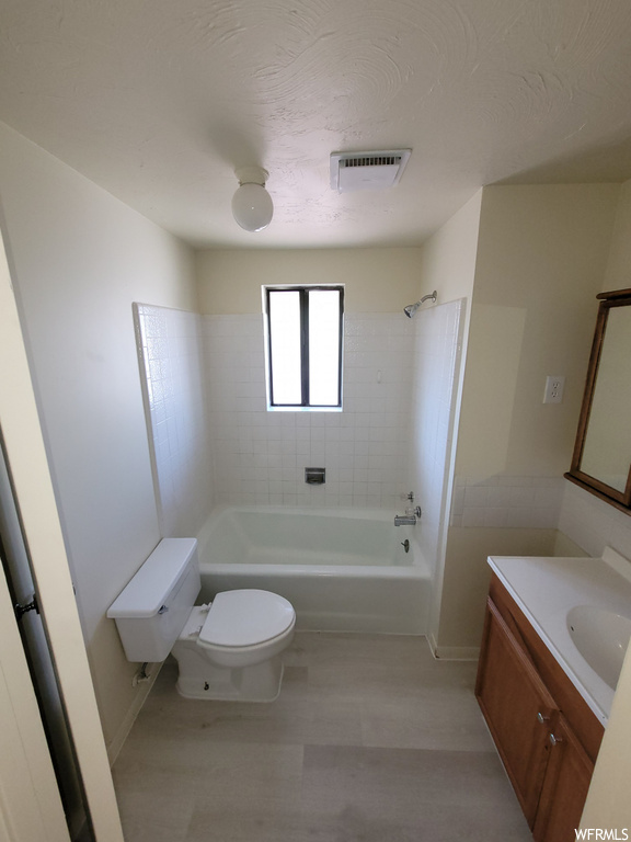 Full bathroom featuring vanity, toilet, and tiled shower / bath