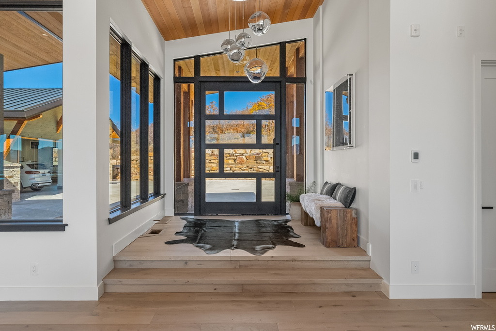 Entrance foyer with high vaulted ceiling, wooden ceiling, and light hardwood / wood-style flooring