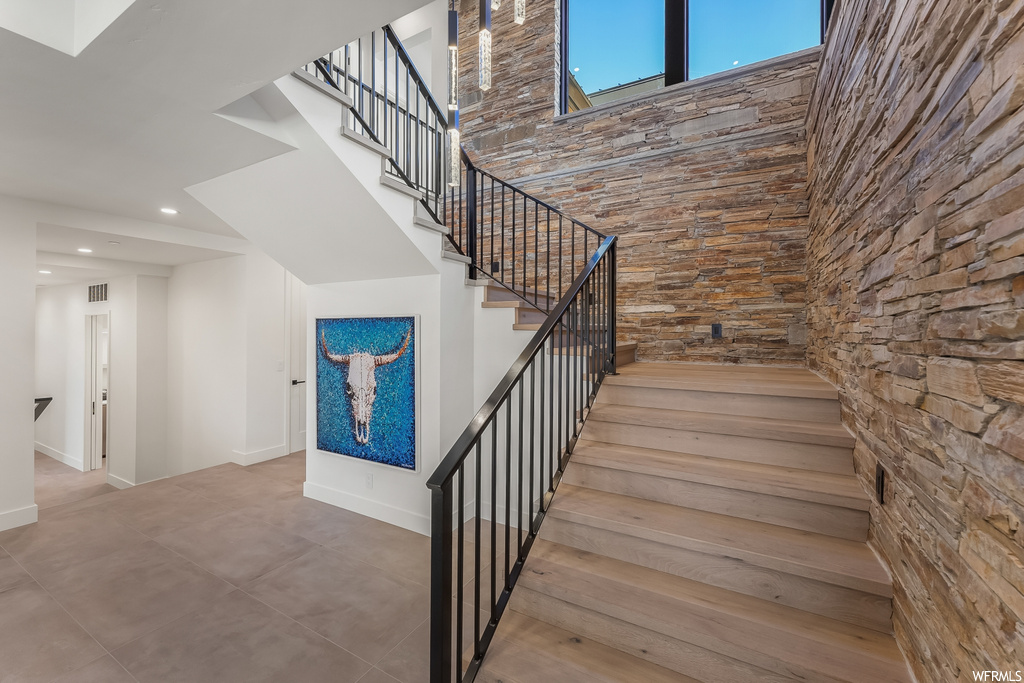 Stairway featuring tile flooring and a high ceiling