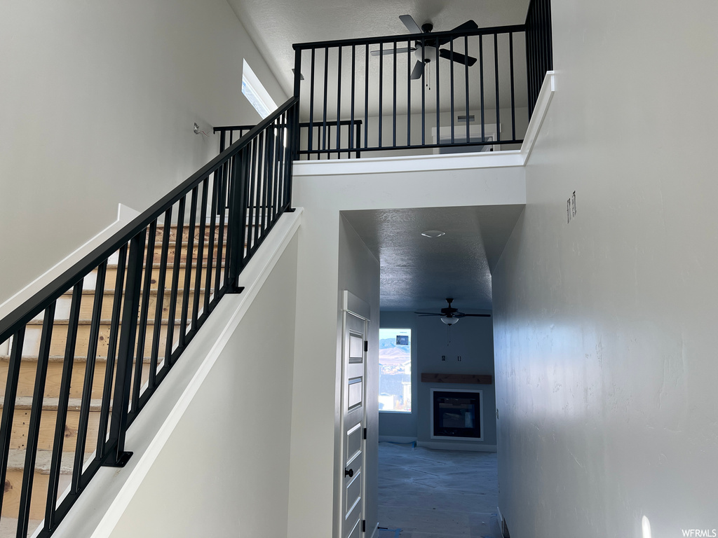 Stairway featuring a high ceiling and ceiling fan