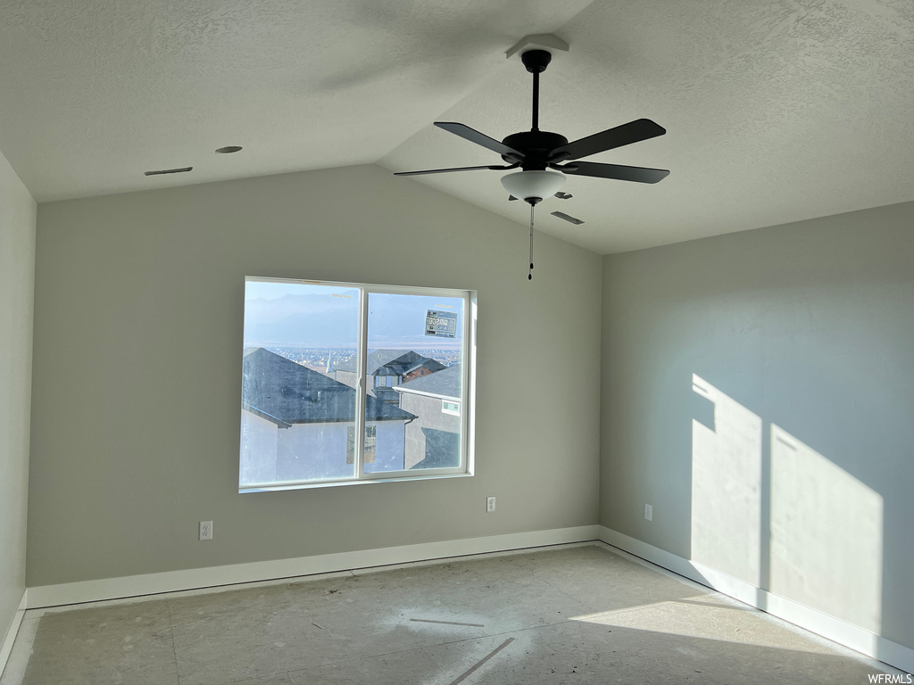 Spare room with ceiling fan and vaulted ceiling