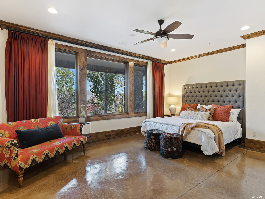 Bedroom featuring concrete flooring, ceiling fan, and ornamental molding