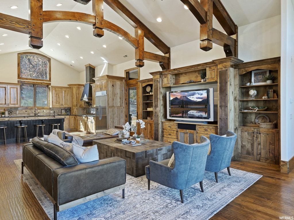 Living room featuring plenty of natural light, dark hardwood / wood-style flooring, high vaulted ceiling, and sink