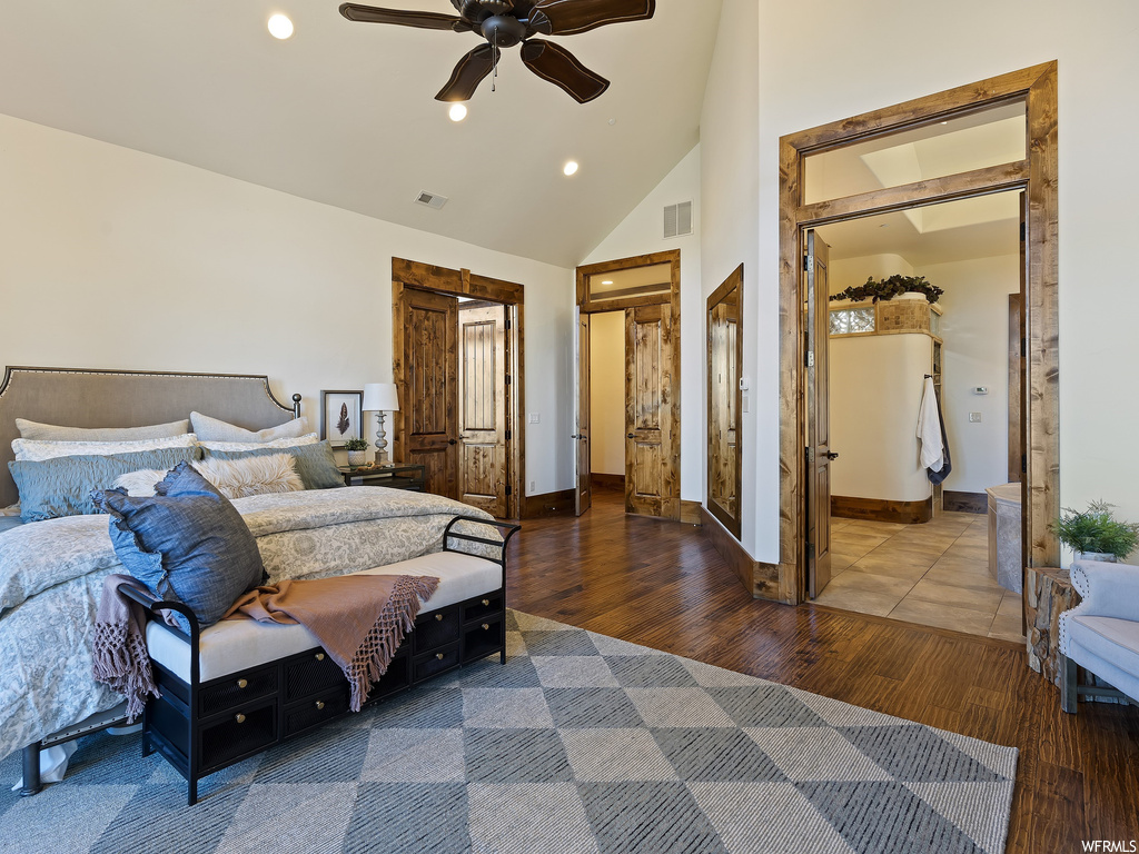 Bedroom with dark hardwood / wood-style flooring, high vaulted ceiling, and ceiling fan
