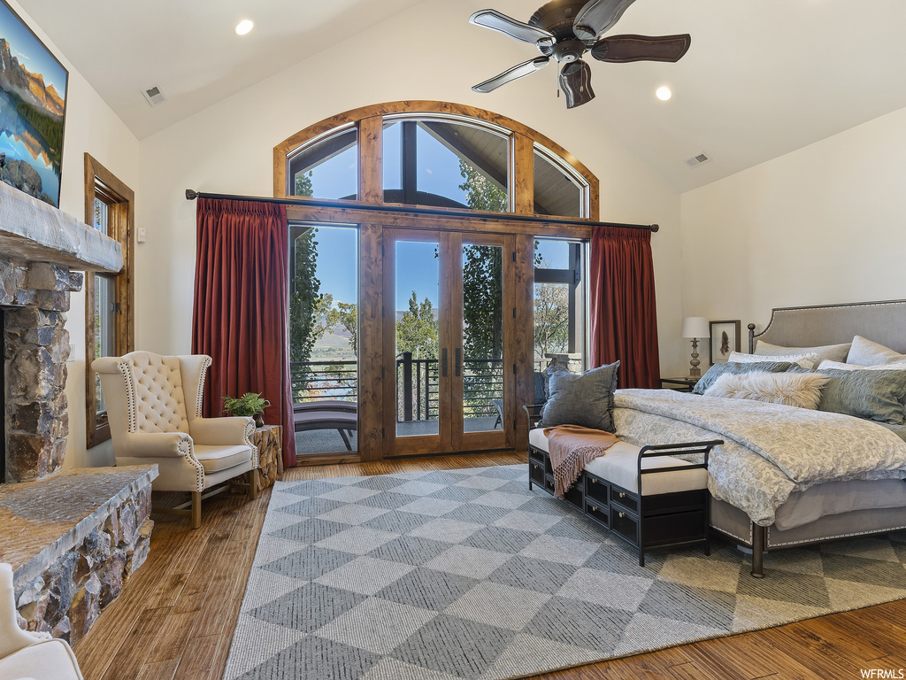 Bedroom with ceiling fan, a fireplace, hardwood / wood-style flooring, and access to outside