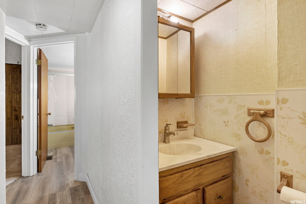 Bathroom featuring shower / bathing tub combination, hardwood / wood-style flooring, and vanity