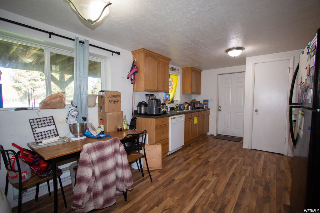 Kitchen featuring dark hardwood / wood-style flooring, fridge, a textured ceiling, and white dishwasher