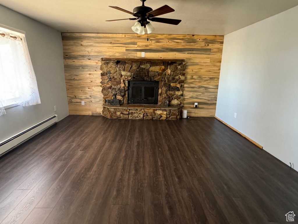 Unfurnished living room featuring dark hardwood / wood-style flooring, a fireplace, and ceiling fan