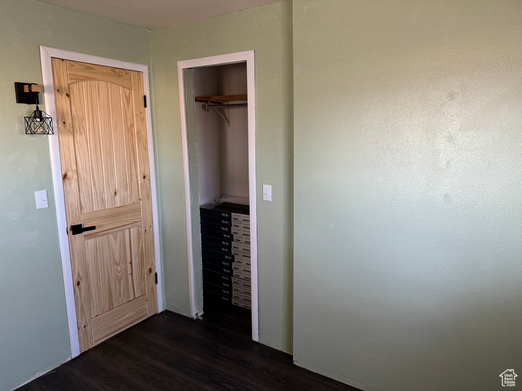 Unfurnished bedroom with dark hardwood / wood-style floors, a closet, and a walk in closet