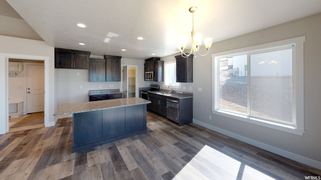 Kitchen featuring a kitchen island, an inviting chandelier, dark hardwood / wood-style floors, and sink