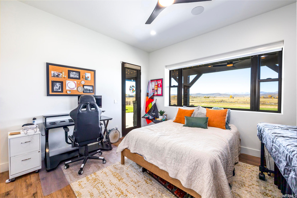 Bedroom featuring access to exterior, light hardwood / wood-style floors, and ceiling fan