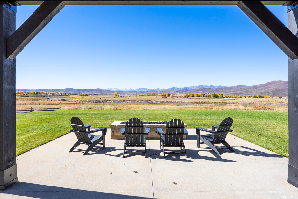 View of patio / terrace featuring a mountain view, a rural view, and an outdoor fire pit