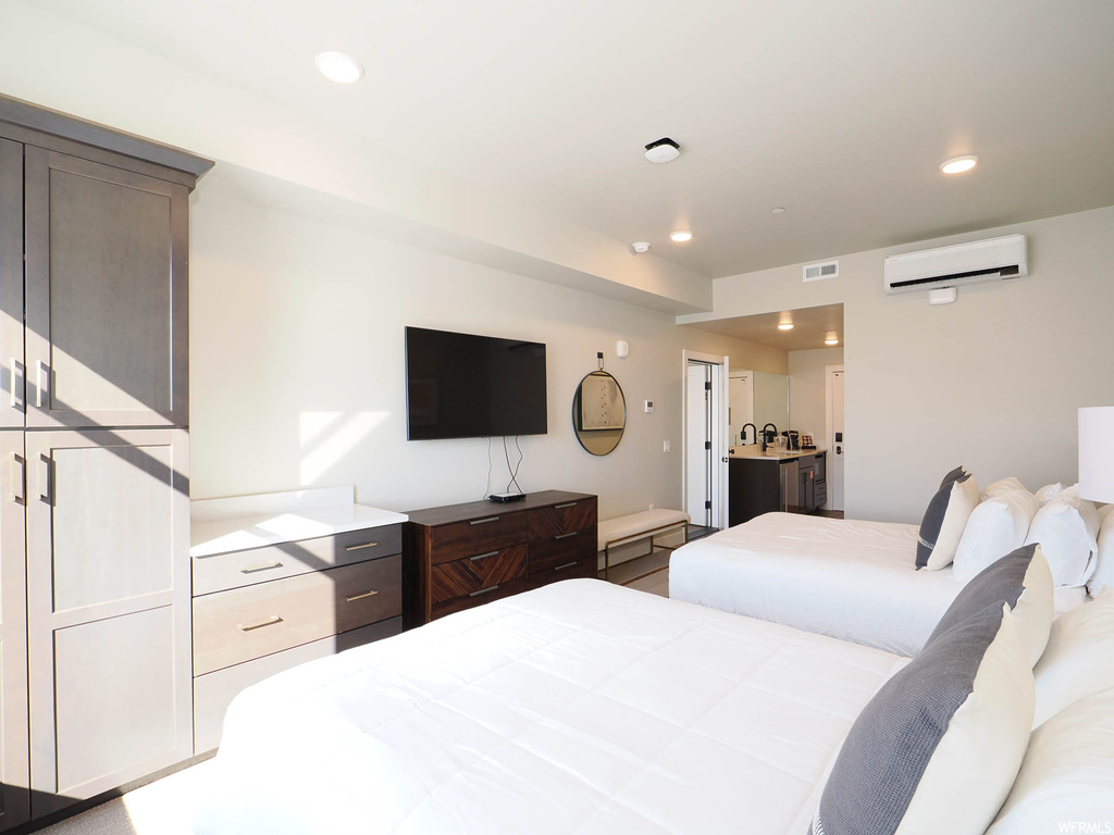 Bedroom featuring a wall mounted air conditioner and connected bathroom