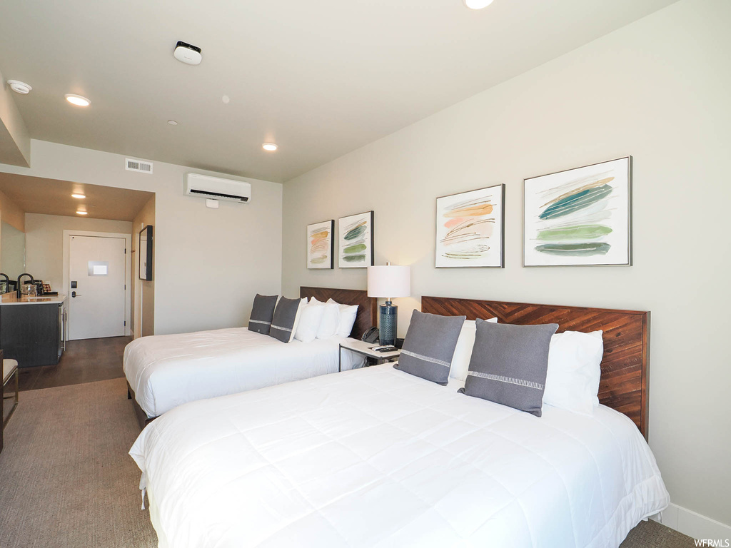 Bedroom featuring a wall mounted air conditioner and dark carpet