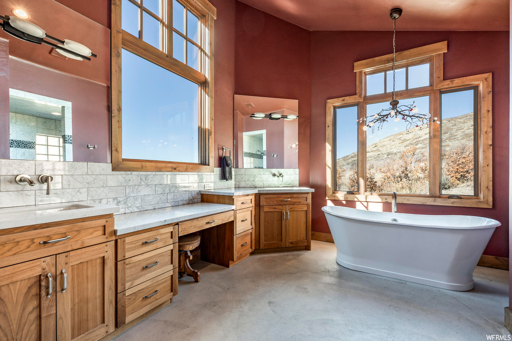 Bathroom with a bath, large vanity, vaulted ceiling, a mountain view, and backsplash