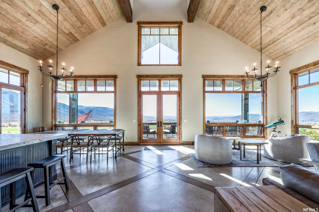 Living room featuring a mountain view, an inviting chandelier, high vaulted ceiling, and beam ceiling