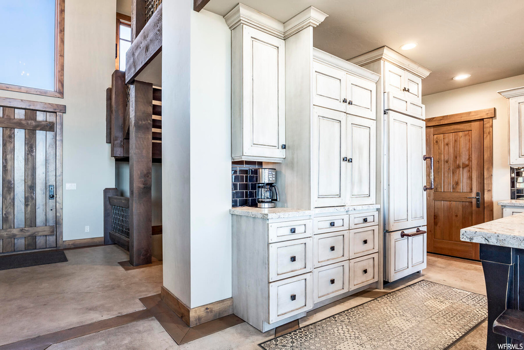 Kitchen featuring white cabinets and light stone countertops