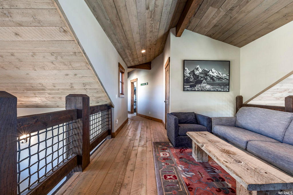 Living room featuring hardwood / wood-style floors, vaulted ceiling with beams, and wood ceiling